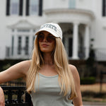Woman wearing a Thorne Estate hat and sunglasses in front of an estate