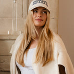 Woman wearing a cap with 'ESTATE' text.
