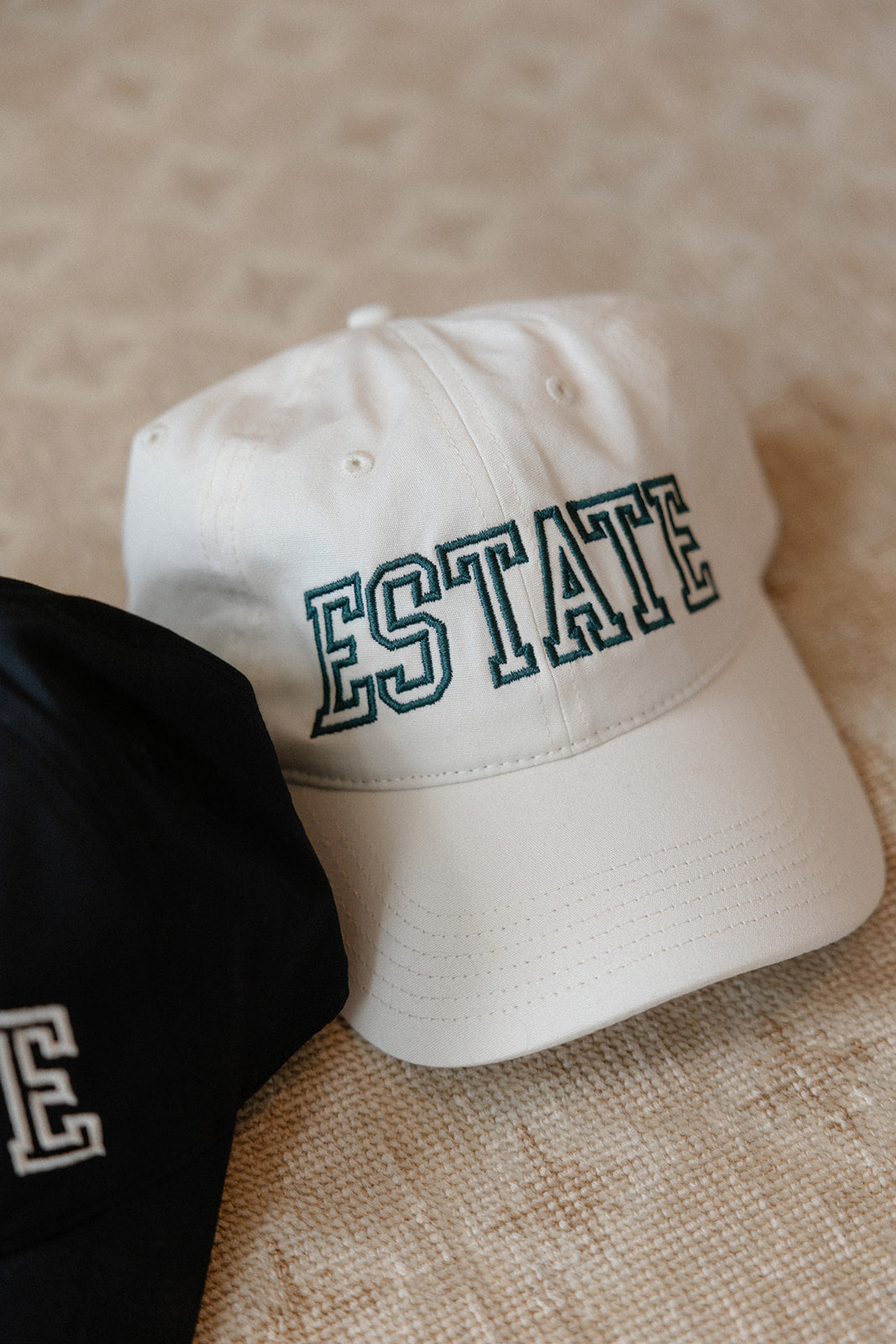 Cream cap with 'ESTATE' text on a textured surface
