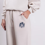 Close-up of Thorne Estate crest embroidery on the cream sweatpant