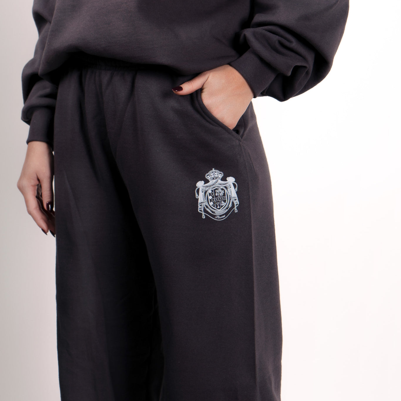 Close-up of Thorne Estate crest embroidery on the navy sweatpant details
