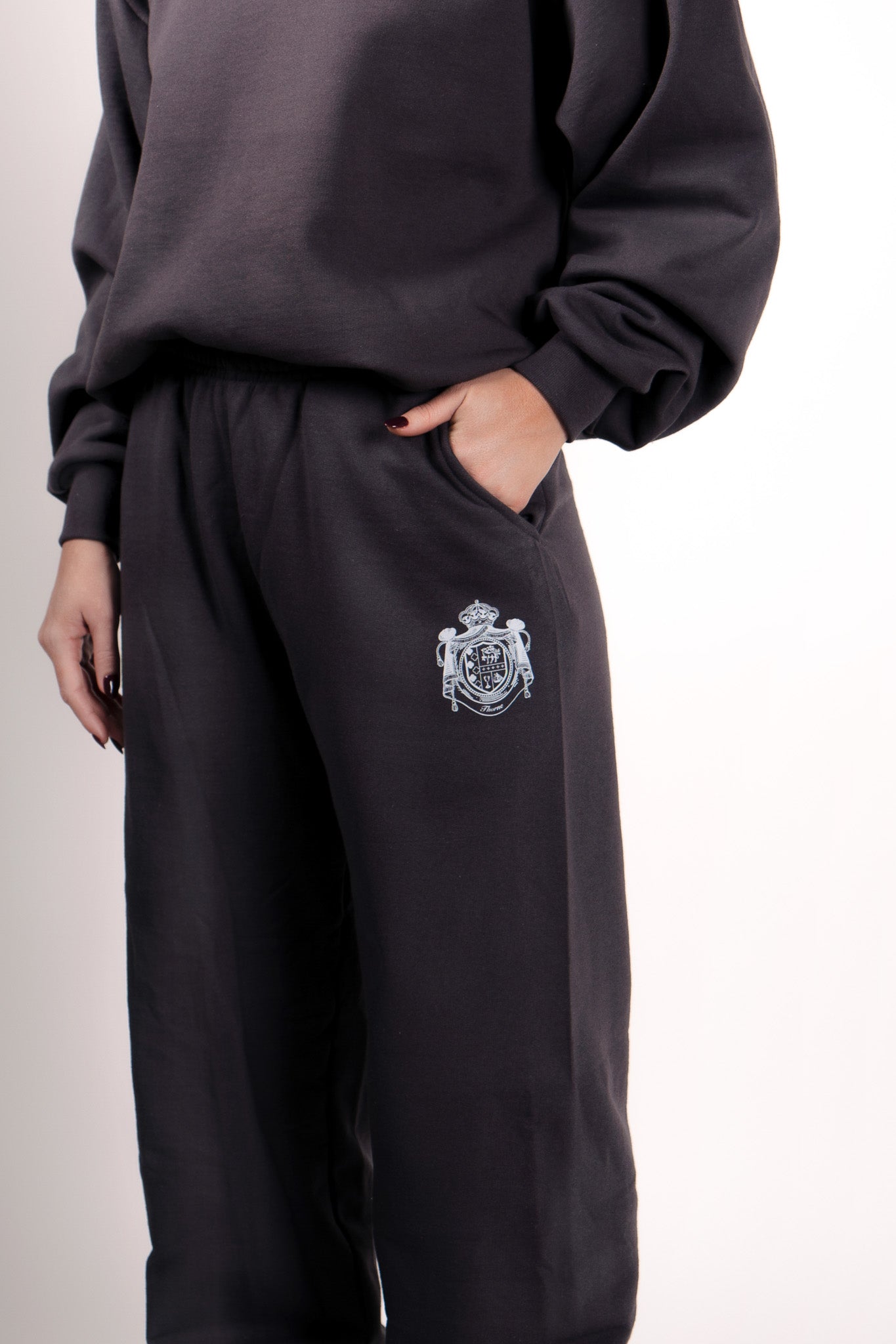 Close-up of Thorne Estate crest embroidery on the navy sweatpant details